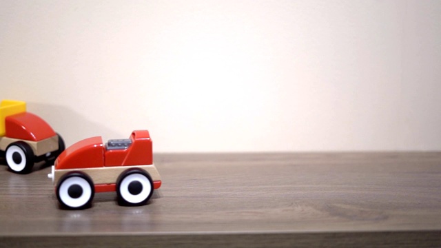 孩子在后院玩红色的玩具车。