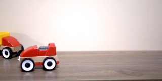 孩子在后院玩红色的玩具车。