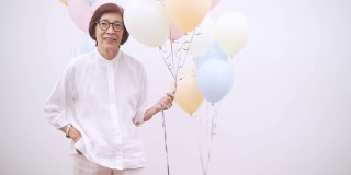 亚洲活跃的老年妇女用彩色气球庆祝生日