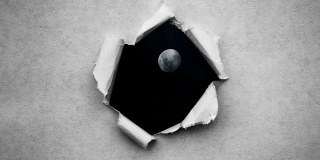 创造性的4k时间拍摄了一个在夜空中发光的满月和漂浮的云的视频，可以通过一个边缘撕裂的圆洞看到，这个圆洞是用复古的老式纸张制成的。