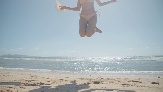 慢动作:微笑年轻的比基尼亚洲女人玩自由在海边海滩热带休息和放松旅游生活理念