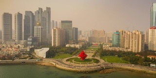 阳光明媚的一天，飞越青岛著名的海湾纪念碑广场，空中延时全景4k中国