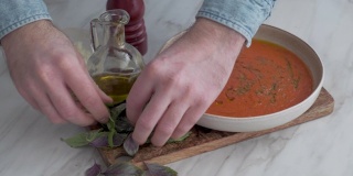 一个男人在端意大利番茄汤