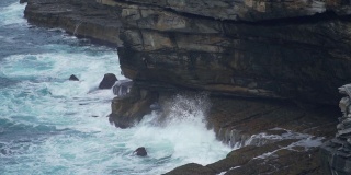 慢动作的海浪击中海岸附近的岩石