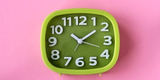 粉红色背景上的白色数字和箭头的绿色时钟