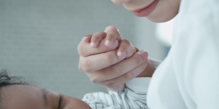 母亲牵着婴儿的手的特写，慢动作