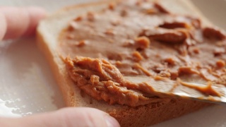把花生酱涂在烤面包上，做三明治视频素材模板下载