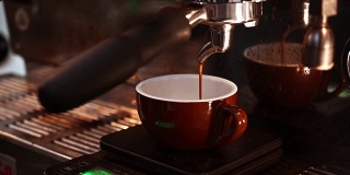 浓缩咖啡从咖啡机倒出来的特写。专业的咖啡酿造。