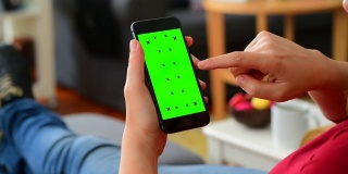 女人在家里使用彩色键屏智能手机