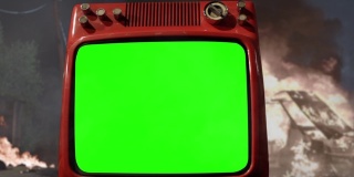 复古电视与绿色屏幕上的背景与一辆着火的汽车。