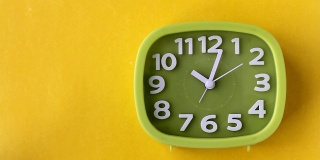 黄色背景上带有白色数字和箭头的绿色时钟，实时显示