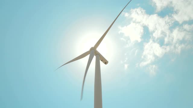风力发电农场白天有蓝天和太阳耀斑。