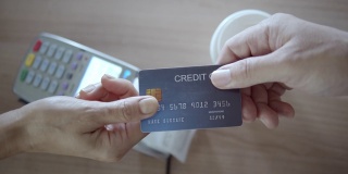 人的手给信用卡给销售人员的特写，慢动作
