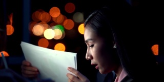 压力很大，忙碌的年轻亚洲女商务人员，晚上在办公室和同事加班。商人和女商人在晚上为商业项目的截止日期进行头脑风暴。
