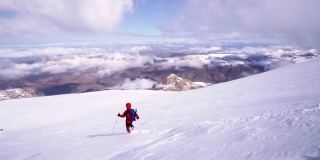 年长的高山攀登者正在冬季攀登高海拔山脉的顶峰