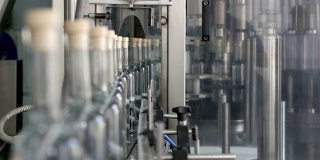 酒精洒在工厂的玻璃瓶里。酒精饮料的加工。