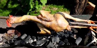 整只鸡在炭炉上烤制