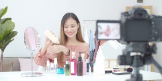 美丽的亚洲女人博客展示如何化妆和使用化妆品。在摄像机前录制在家的视频直播。商业在线影响者对社交媒体的概念。