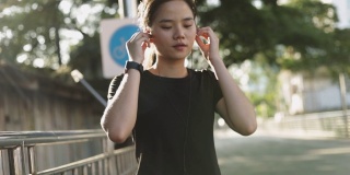 亚洲女性慢跑锻炼跑步听音乐。