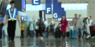 人群带着行李在国际机场行走的时间流逝。