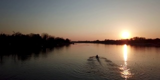 职业运动员在日落时练习划艇。