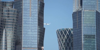 飞机在多哈城市摩天大楼上空飞行的特写视频，卡塔尔。