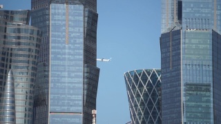 飞机在多哈城市摩天大楼上空飞行的特写视频，卡塔尔。视频素材模板下载