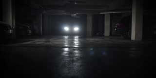 黑暗的地下停车场混凝土地面车前灯背光小车在滑行低角度拍摄