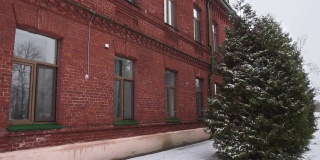 古老的红砖建筑18 19世纪的冬天白天下雪。俄罗斯帝国最古老的旅馆或旅舍，在暴风雪、恶劣天气中接待游客。前军营附近的雪树