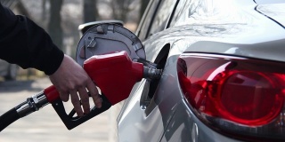 特写的人填补汽油汽油燃料在汽车在加油站