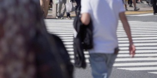 一群上班族穿过东京涩谷十字路口，日本。