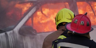 后视图亚洲消防员穿消防服。消防演习中消防队员在一辆汽车上与火搏斗消防站交通事故概念。慢动作