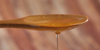 Honey falling from a wooden spoon