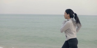 有吸引力的亚洲运动运动员跑步女性锻炼在日落海滩健身和健康的生活方式的概念。
