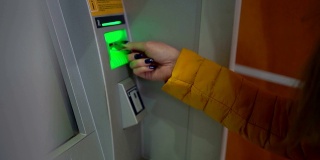 女子将信用卡插入自动取款机