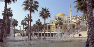 阿尔巴尼亚城的喷泉、棕榈树和清真寺