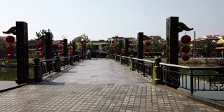 越南广南会安- 2020年3月9日:时间流逝。越南会安，游客们带着中国传统灯笼穿过桥。炎热的晴天，蔚蓝的天空。观光。锅吧。