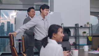 一群年轻的亚洲商人在晚上的办公室会议室里交易和签署合同或协议后握手庆祝。视频素材模板下载