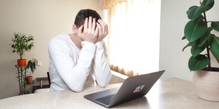 震惊沮丧的白种商人学生感到压力看着电脑屏幕，担心问题读糟糕的网上新闻，远程工作