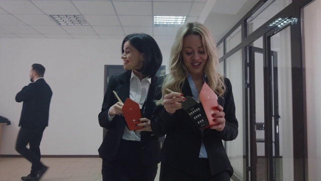 商务女性在办公室走廊里聊天、吃饭
