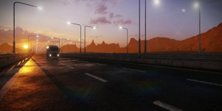 近距离拍摄卡车在高速公路上行驶，背靠沙漠山脉和美丽的日落
