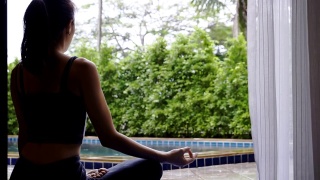 亚洲女性在家练习瑜伽练习灵活平衡冥想，瑜伽坐半莲花运动，健康积极的生活方式理念视频素材模板下载