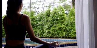 亚洲女性在家练习瑜伽练习灵活平衡冥想，瑜伽坐半莲花运动，健康积极的生活方式理念