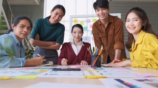 亚洲女性领导者建议ux/ui设计师关于在桌子上和在现代办公室看着摄像头的移动应用界面线框设计。创意数字发展机构视频素材模板下载