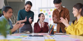 亚洲女性领导者建议ux/ui设计师在现代办公室的桌上进行手机应用界面线框图设计。创意数字发展机构