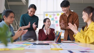 亚洲女性领导者建议ux/ui设计师在现代办公室的桌上进行手机应用界面线框图设计。创意数字发展机构视频素材模板下载