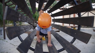 婴儿在一个绳子小镇玩。男孩爬进了儿童器材里。一个孩子在操场上的桥上爬行。视频素材模板下载