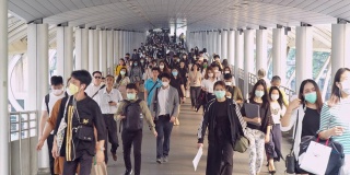 4K分辨率慢镜头拍摄亚洲人在早高峰时间在曼谷上班时戴着预防冠状病毒或新冠病毒的面罩和空气中的微尘pm 2.5