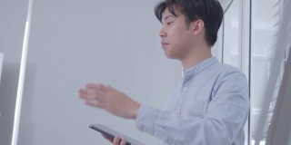 自信的亚洲商人团队领导手持数字平板电脑，展示一个新项目
