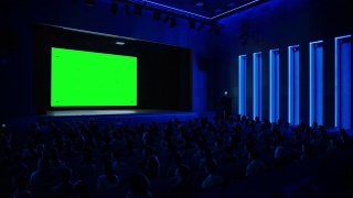 在电影院，观众在绿色屏幕上观看新大片。人们观看视频游戏比赛流媒体，现场音乐会视频，新产品发布预告片视频素材模板下载